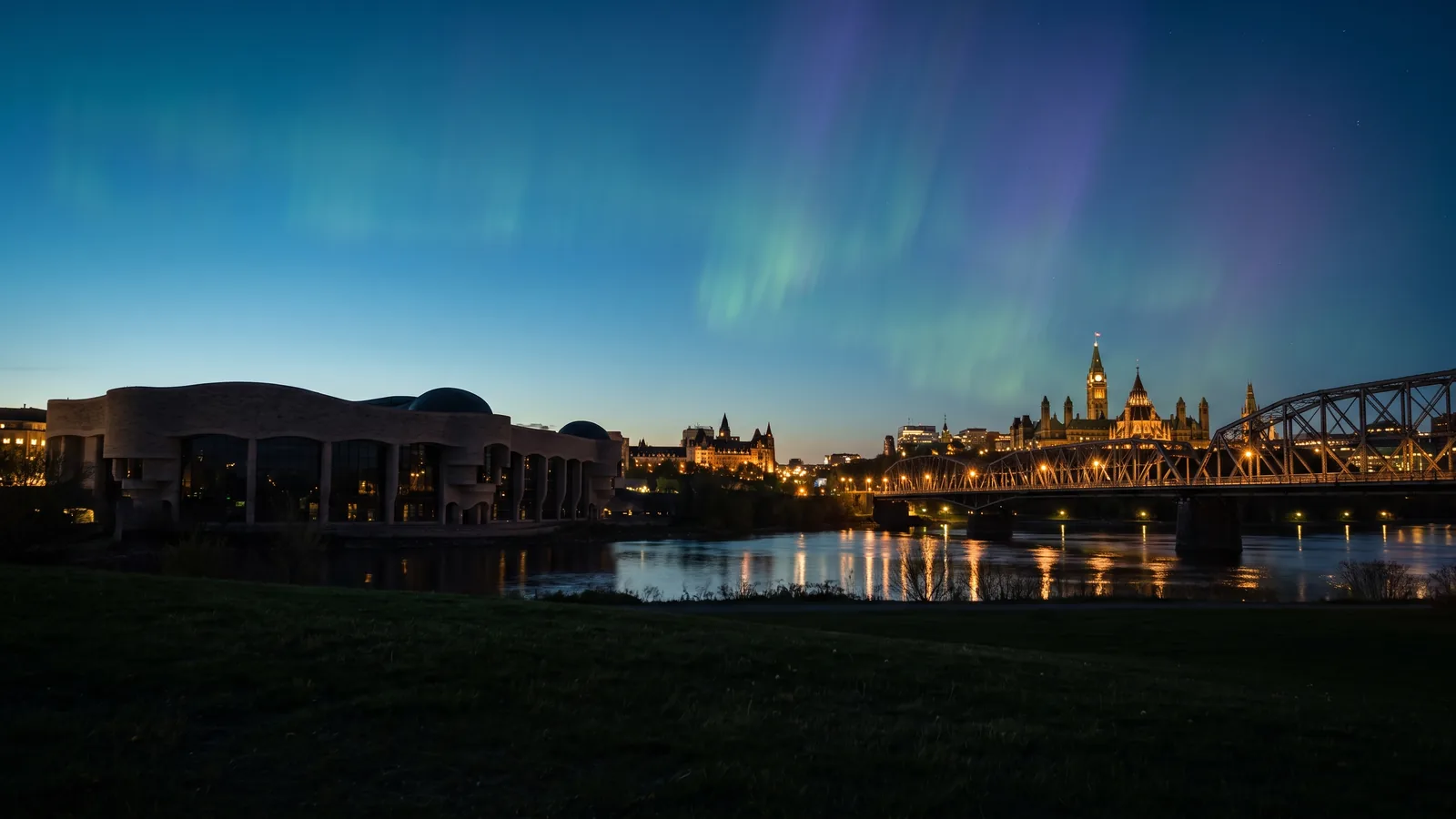 The Canadian Museum of History and the Alexandra Bridge seen from Hull at dusk under the northern lights